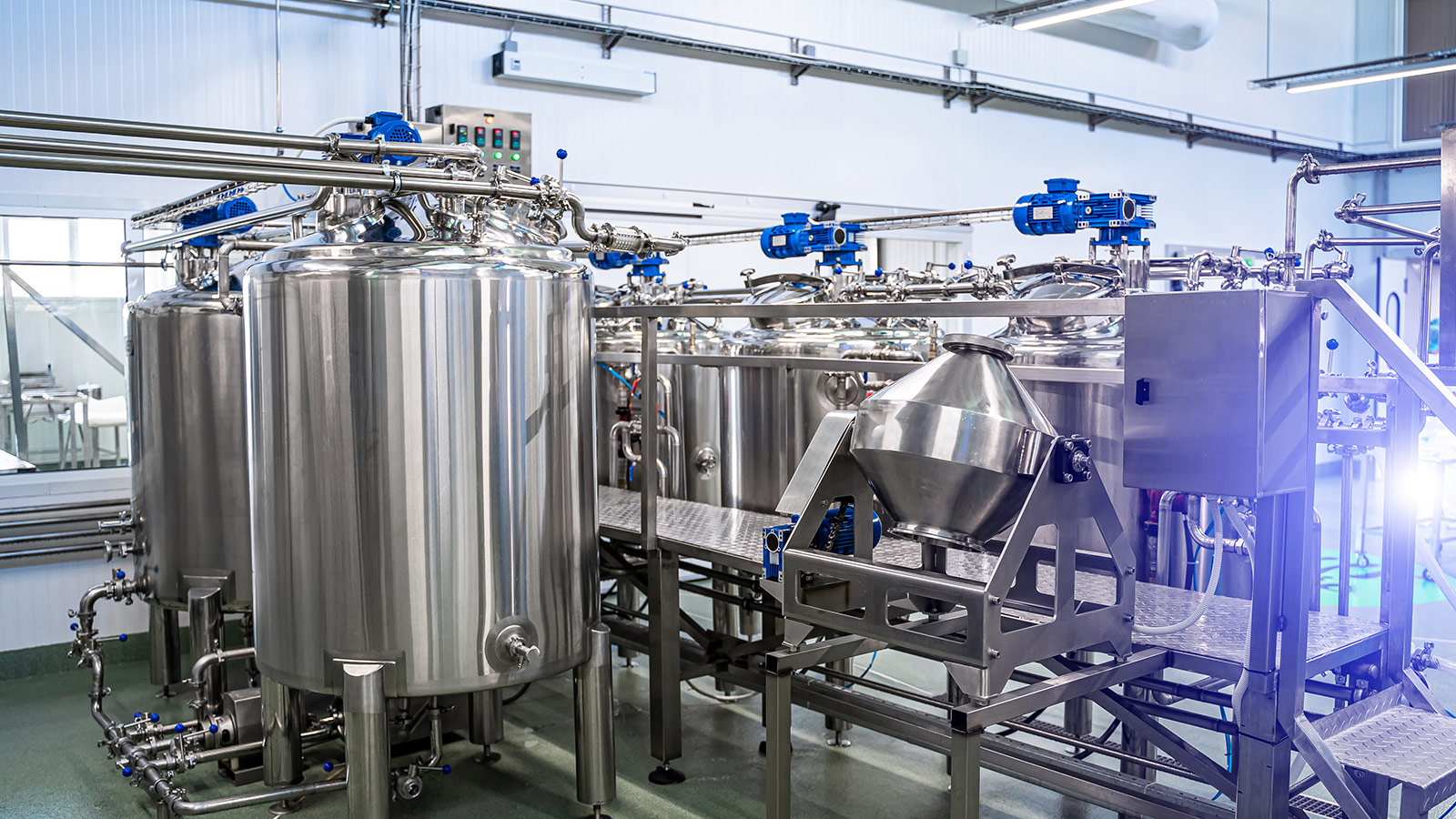 Food and beverage processing facility with stainless steel tanks, sanitary piping, and industrial equipment for hygienic manufacturing. Food and beverage processing facility with stainless steel tanks, sanitary piping, and industrial equipment for hygienic manufacturing.