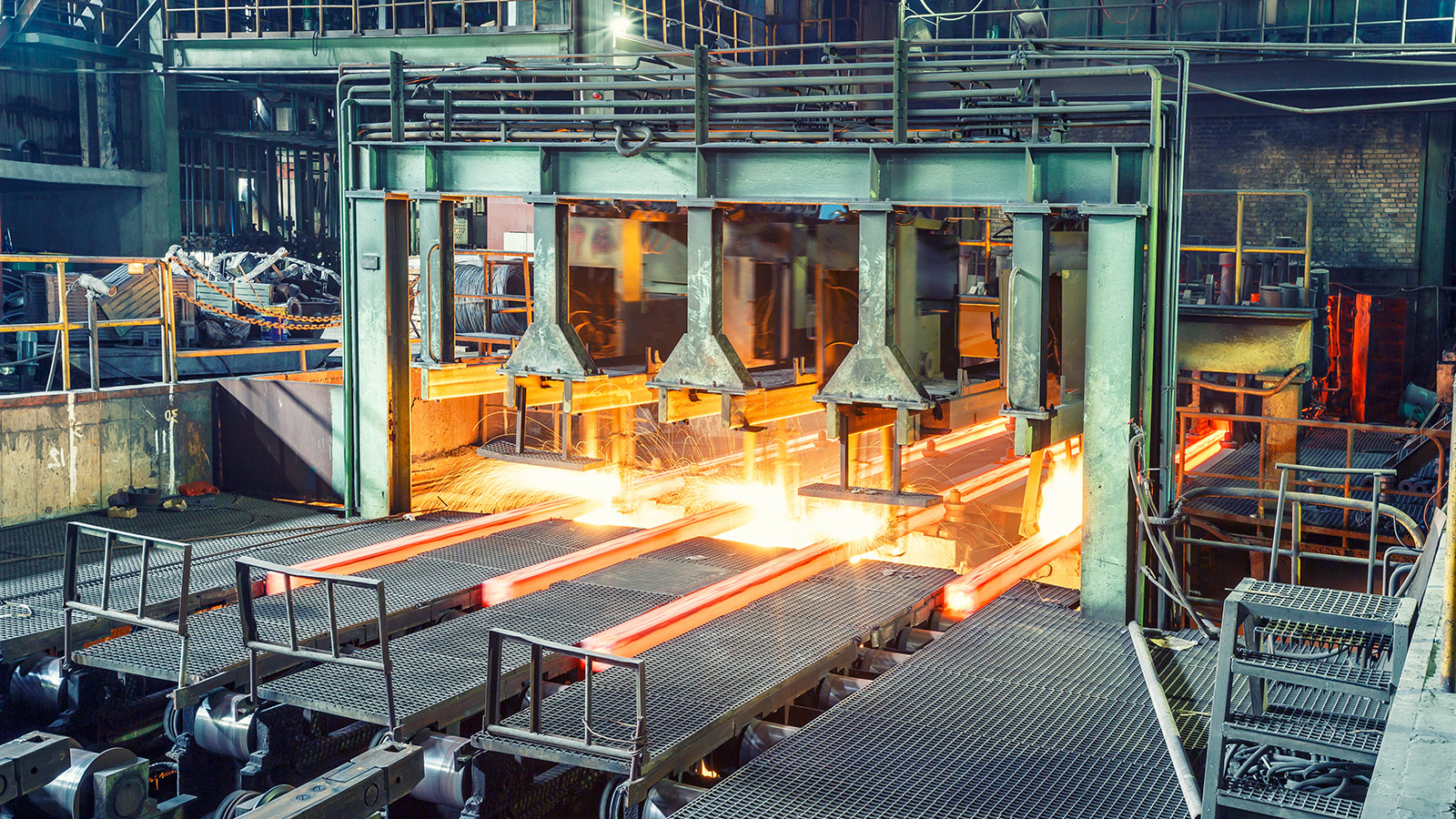 Metal processing facility with a hot steel production line and industrial equipment used in continuous manufacturing. Metal processing facility with a hot steel production line and industrial equipment used in continuous manufacturing.