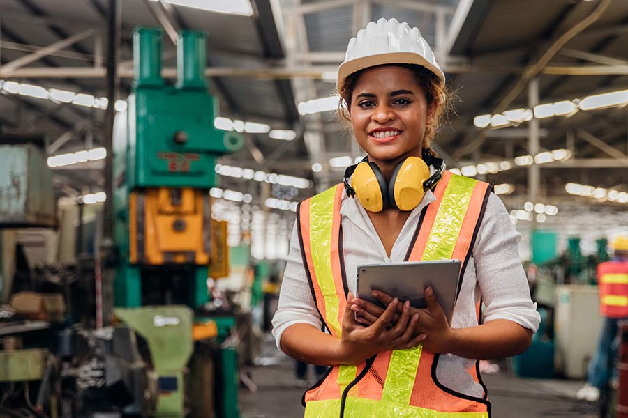 Engineer in factory smiling at camera